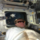 PILOT BRENT JETT ON THE AFT FLIGHT DECK DURING DOCKING MANEUVER, MIR IS VISIBLE IN THE WINDOW BEHIND HIM
